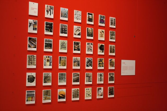 Eine rote Wand im Schopenhauer-Studio, an der mit Nadeln Postkarten befestigt sind