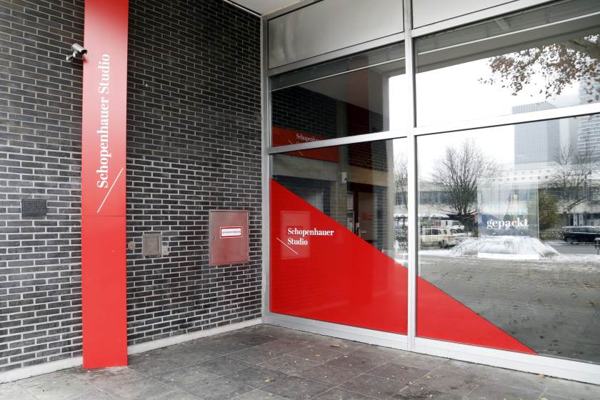 Außenansicht der Zentralbibliothek, am Fenster und an der Wand befinden sich rote Hinweise zum Schopenhauer-Studio