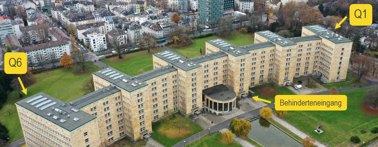 Außenansicht des IG-Farbenhaus, die äußersten Flügel links und rechts sind mit Q1 bzw. Q6 beschriftet, zentral neben der Rotunde ist ein Behinderteneingang markiert